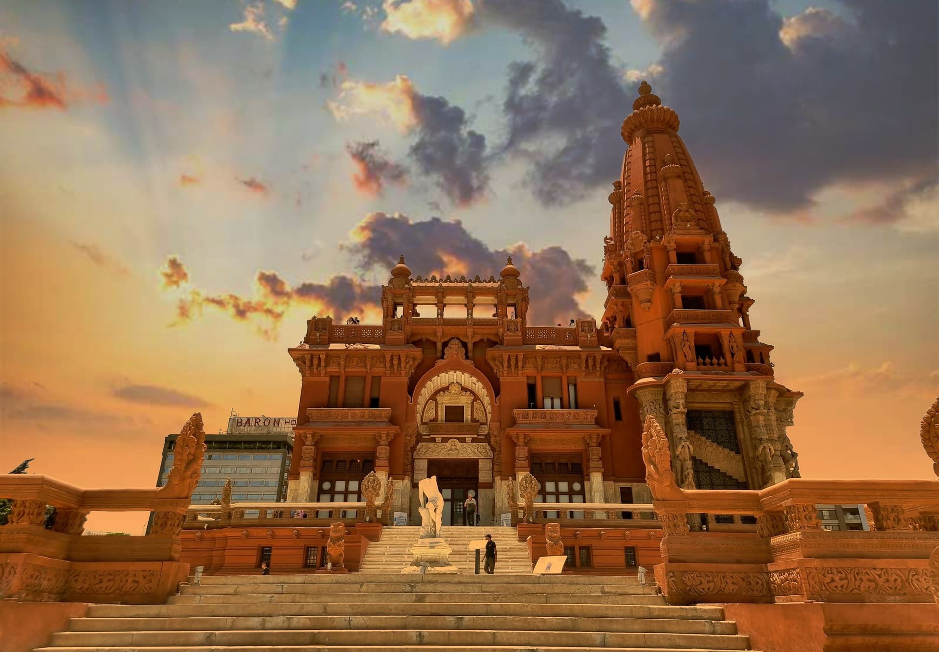 The red towers and carved terraces of the Baron Empain Palace in Heliopolis, Cairo, lit by a low evening sun