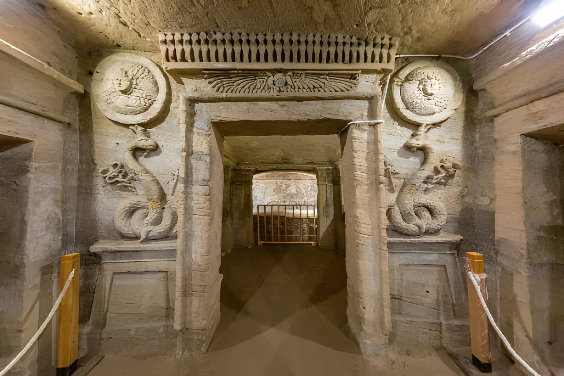The carved doorway of the main tomb chamber at Kom el-Shoqafa in Alexandria, flanked by serpents in relief and round Medusa shields