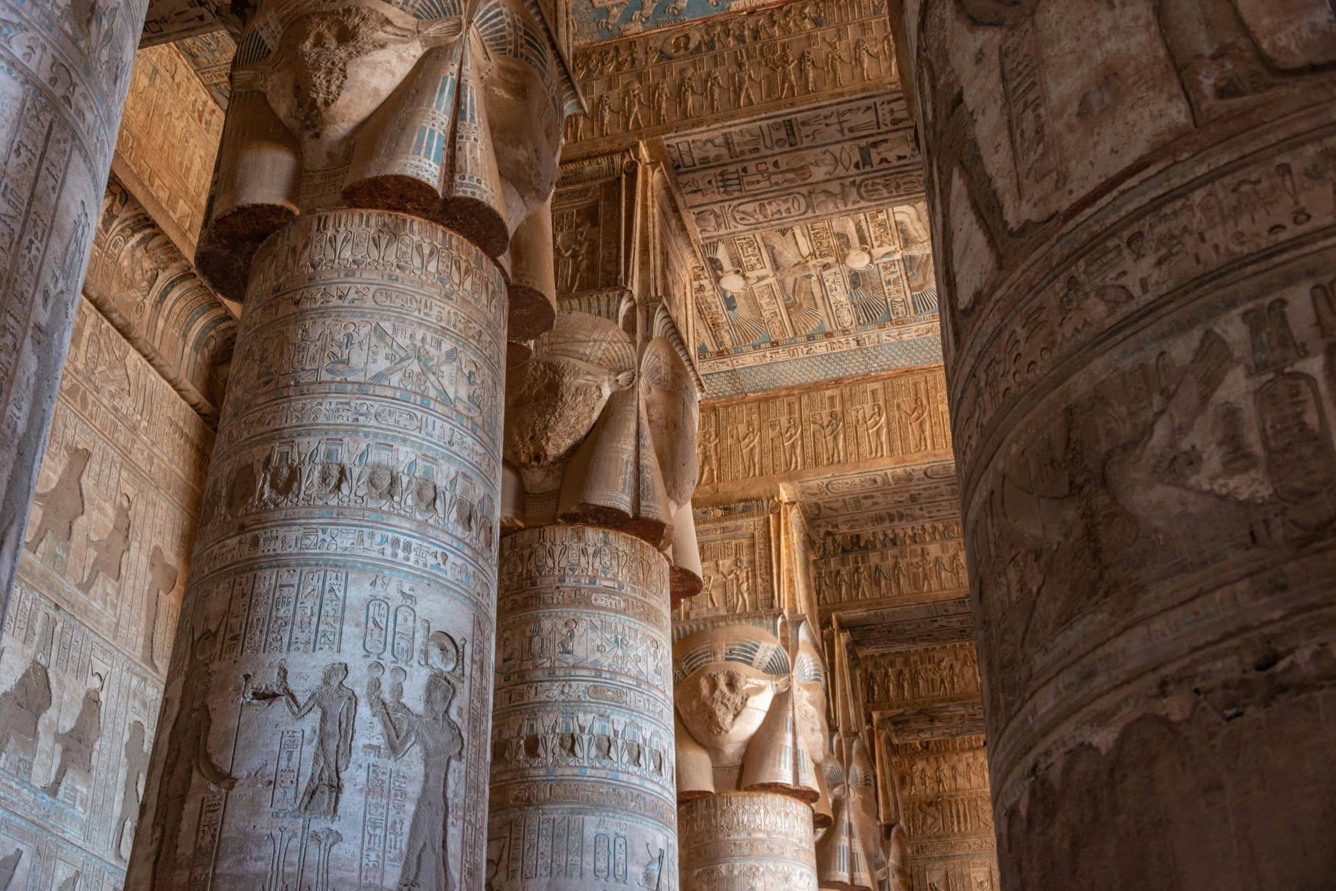 The restored painted ceiling and Hathor-headed columns inside the Temple of Hathor at Dendera