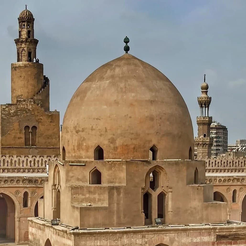 The great dome of the Mosque of Ibn Tulun with its spiral minaret rising beside it above the roofs of Cairo