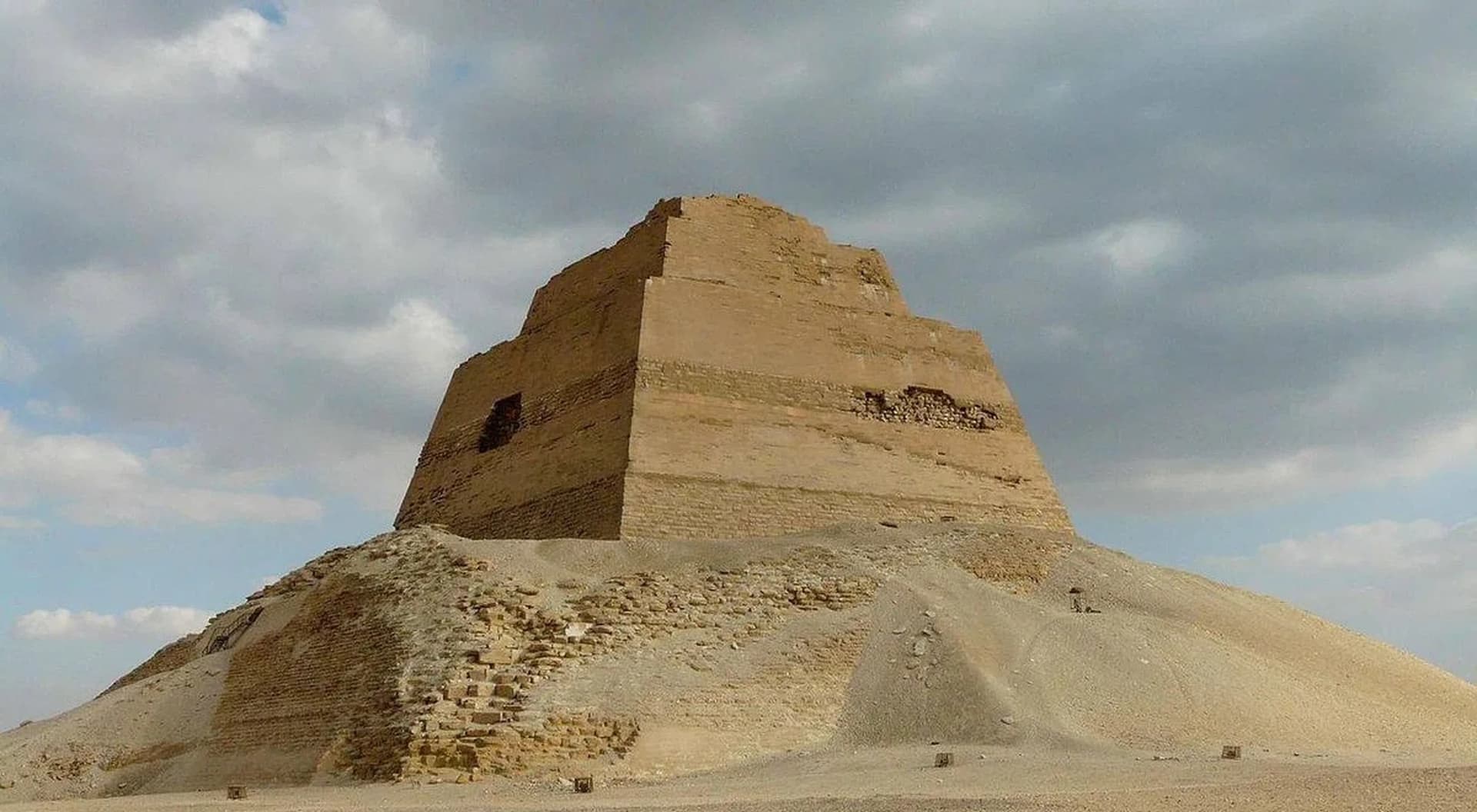 The three-stepped tower of the Meidum pyramid rising out of the mound of its own collapsed casing in the desert
