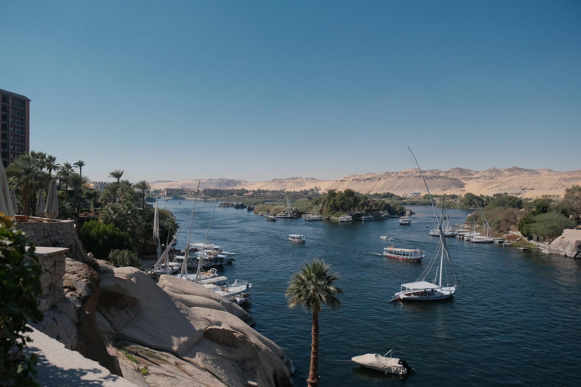Feluccas on the Nile at Aswan with Elephantine Island and its granite boulders behind