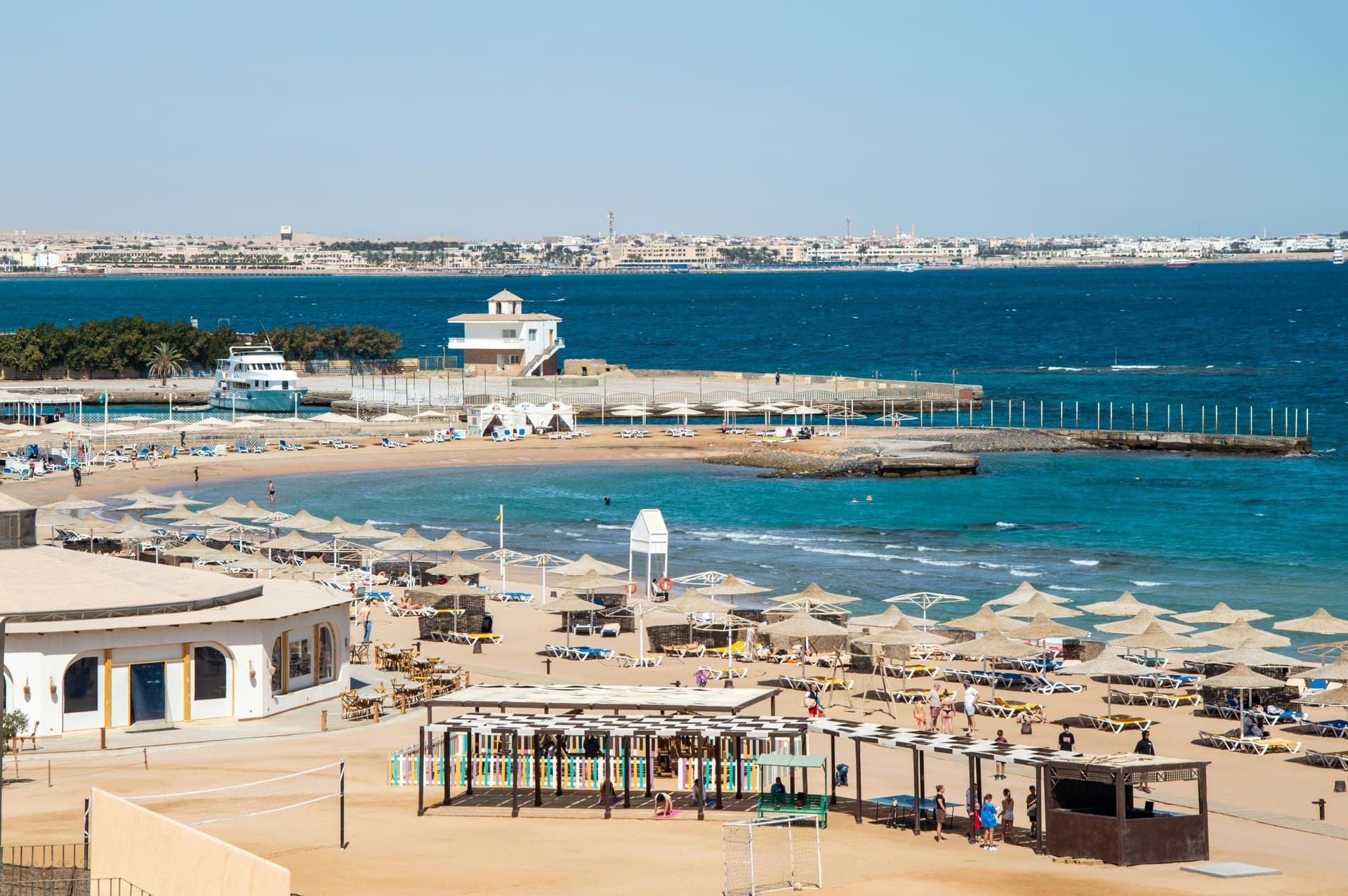 Turquoise water and a wide sandy beach lined with resorts on the Red Sea coast at Hurghada
