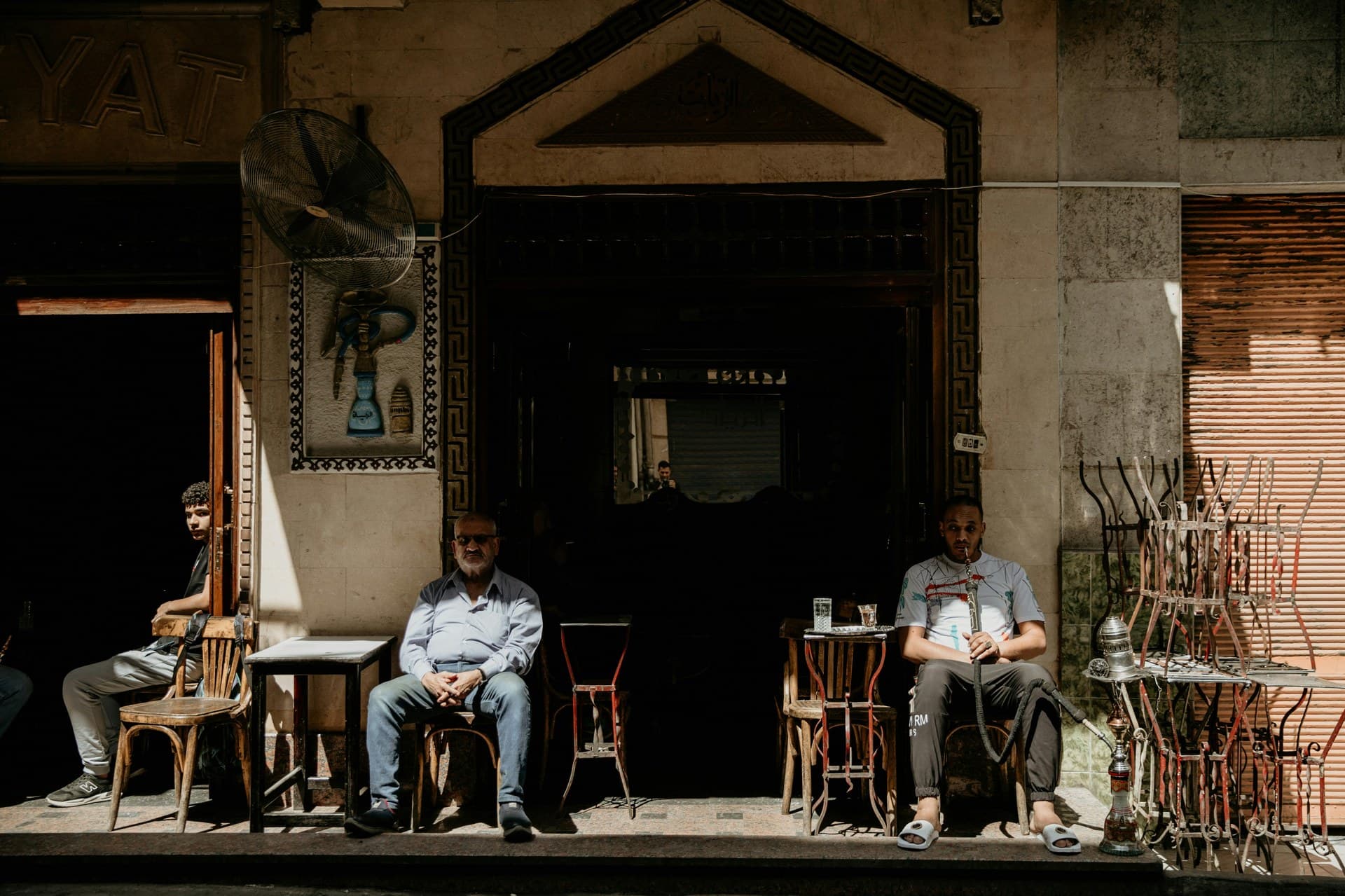 A Cairo street with shopfronts and people walking in the late afternoon